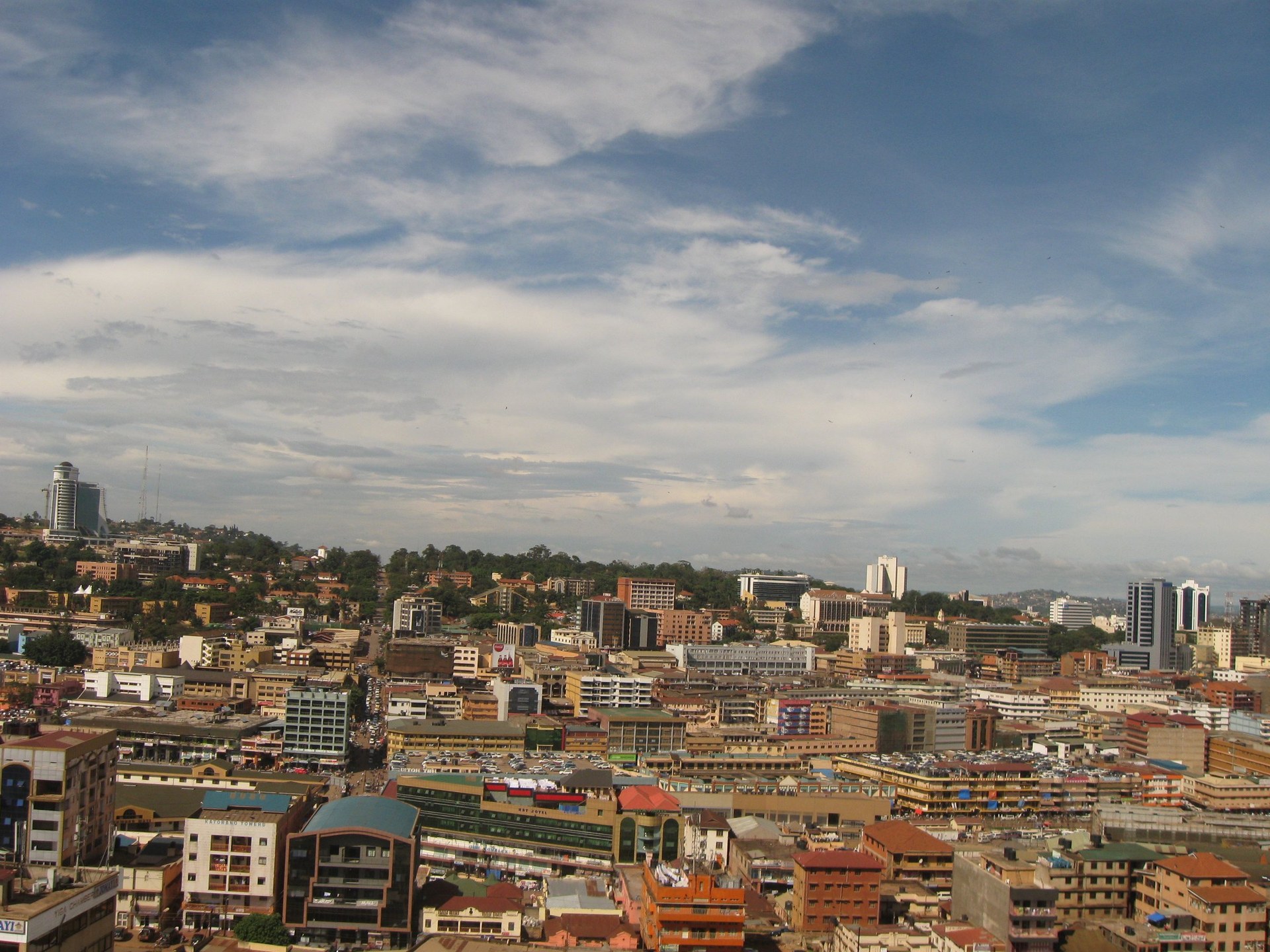 Central Kampala's towers and rooftops, with green hills beyond, seen from a minaret on Old Kampala hill